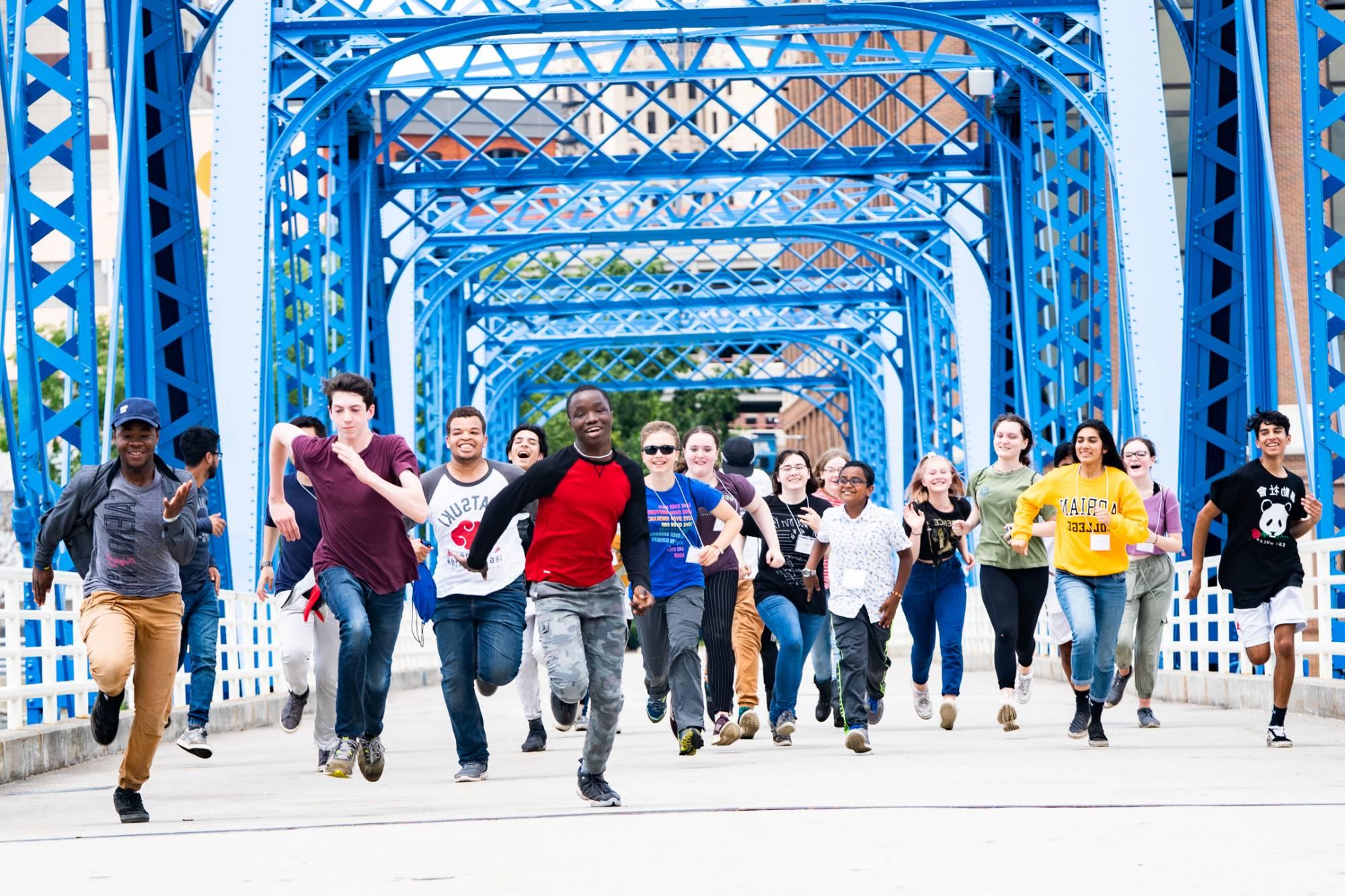 Students running enthusiastically across the Blue Bridge